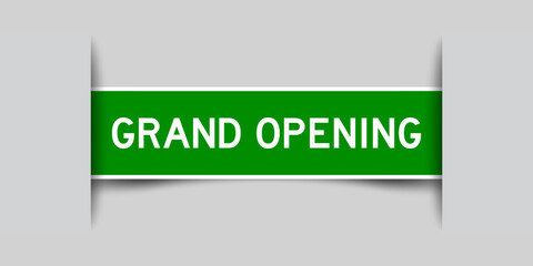 Inserted green color label sticker with word grand opening on gray background