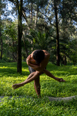 young man, doing yoga or reiki, in the forest very green vegetation, in mexico, guadalajara, bosque colomos, hispanic,