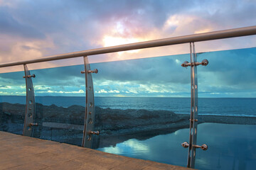 Modern bridge construction detail made by steel and glass on the beach with cloudy sky background