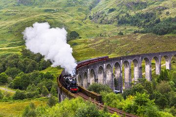 Fototapeta premium Glenfinnan railway viaduct in Scotland with the Jacobite steam train passing by