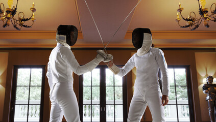 Two female fencing athletes fight in old fencing hall
