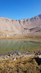 Transparent mountain lake surrounded by rocks. The water is like a mirror, reflecting the rocks and...