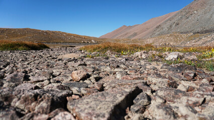 Natural paving stones made of stones in the mountains. The trail leads to a moraine lake. There is...