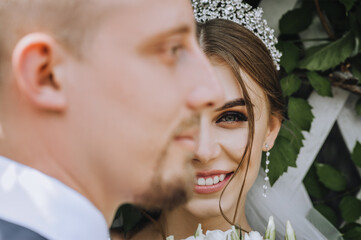 Two faces of a bearded groom and a beautiful bride with a diadem close-up. Wedding photography,...