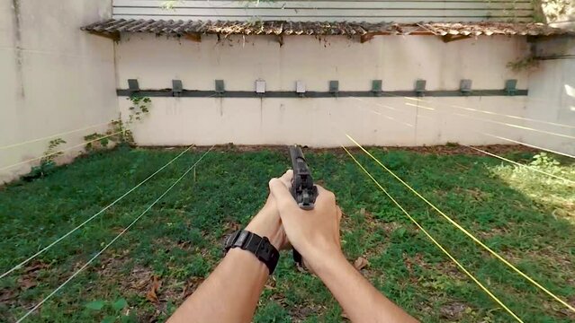 POV Pistol handgun weapon in hand in first person view shooting a pistol in shoot range indoor with smoke effect
