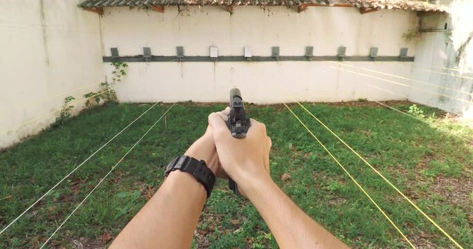 POV Pistol handgun weapon in hand in first person view shooting a pistol in shoot range indoor with smoke effect