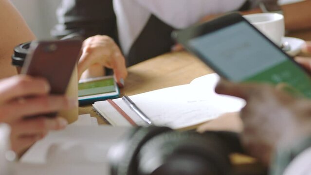 Smartphone, mobile app and creative people in business meeting planning strategy, review ux design and technology innovation. Cellphone screen in hands with creative teamwork of online website design