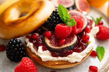 Toasted baggels with red fruit jam, blackberries, raspberries and cheese, figs based on fresh cheese. vegan breakfast.