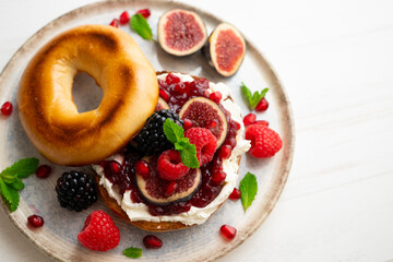 Toasted baggels with red fruit jam, blackberries, raspberries and cheese, figs based on fresh cheese. vegan breakfast.
