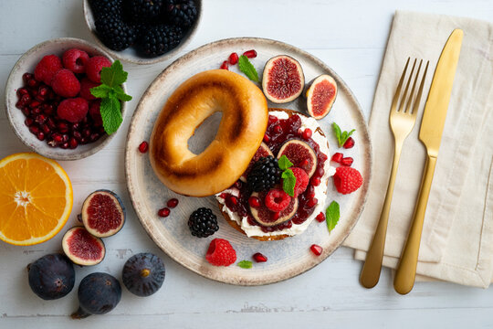 Toasted baggels with red fruit jam, blackberries, raspberries and cheese, figs based on fresh cheese. vegan breakfast. - Powered by Adobe
