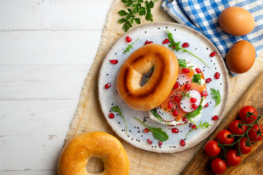 Toasted baggels with salmon, cream cheese, arugula, radishes and pomegranates.