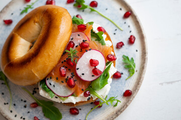Toasted baggels with salmon, cream cheese, arugula, radishes and pomegranates.