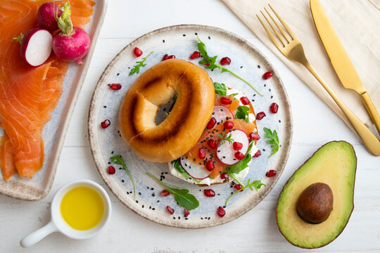 Toasted baggels with salmon, cream cheese, arugula, radishes and pomegranates.