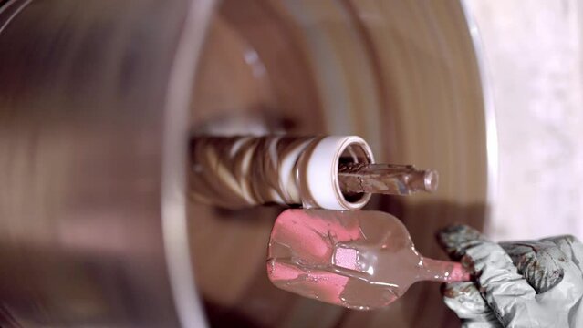 Crop person with spatula mixing chocolate in machine