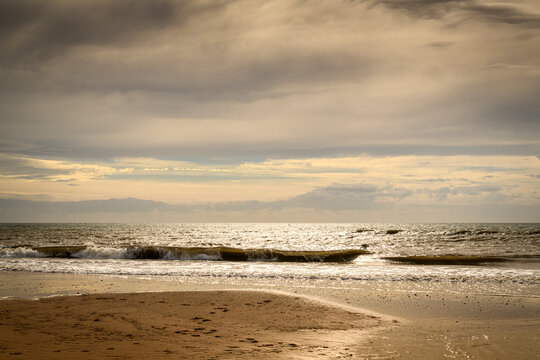 An autumnal HDR seacape image of Fleetwood beach with calm seas, hazy sun and solitude, Lancashire, England.