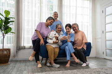 Fototapeta na wymiar Group of elderly in a nursing home make a selfie on a smartphone with elderly caregivers.