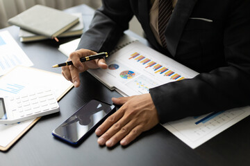 Businessman in the office financial analysis and bookkeeping using smartphone.