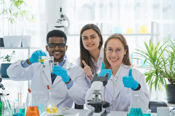 Team of smiling scientist or researcher in laboratory testing cbd oil extracted from a marijuana...