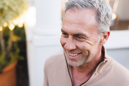 Happy Caucasian Man Standing Outside House And Looking Away