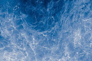 Obraz premium Blue purple sea surface with waves, splash and bubbles