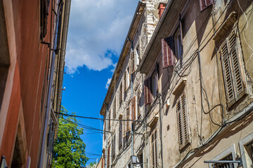 old, colorful houses and narrow streets in the center of the old town of Pula. In the background, port oddities