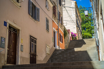 old, colorful houses and narrow streets in the center of the old town of Pula. In the background, port oddities