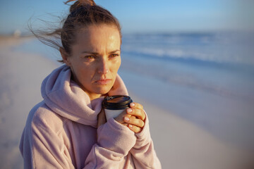 elegant woman in cosy sweater at beach in evening