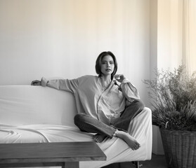 Obraz premium Young beautiful lady sitting at living room,relax time,portrait model posing,black and white tone