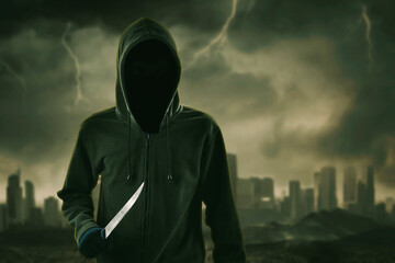 Hooded man holding a knife