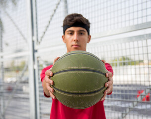 Athletic male playing basketball outdoors. 