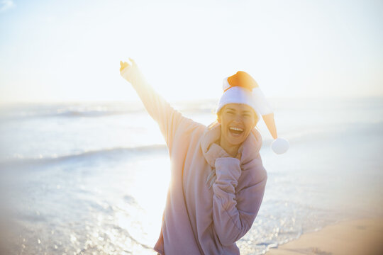 Happy Woman In Cosy Sweater Having Fun Time At Beach In Evening