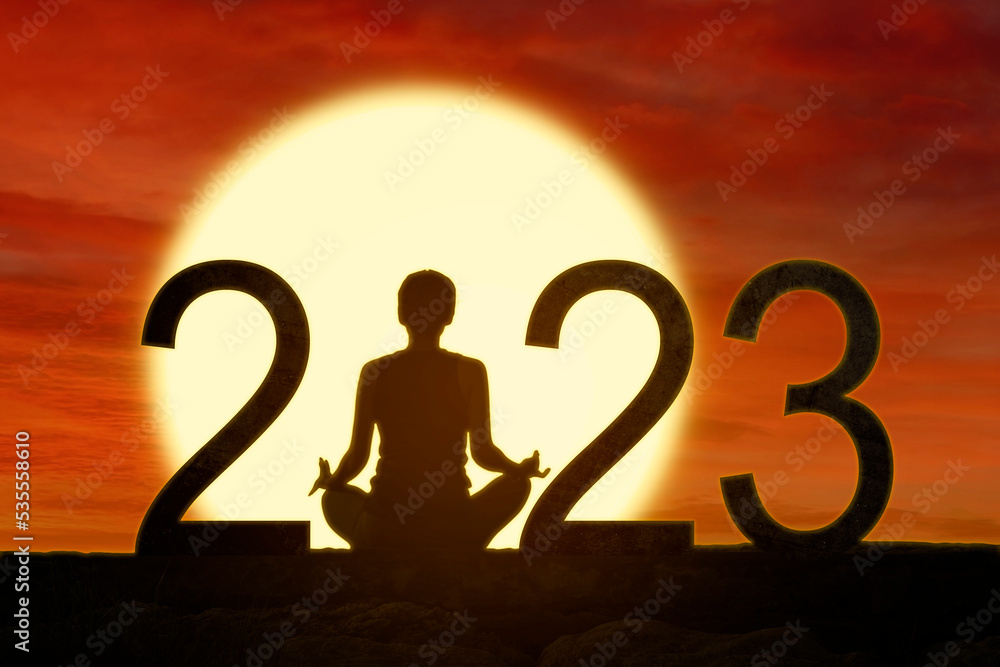 Wall mural woman practice yoga while sits with 2023 numbers