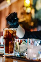 hands of a bartender with black gloves making cocktail on a bar counter.