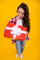 Happy teenager, positive and smiling emotions of teen girl. Child 12-14 years old with gift on isolated background. Birthday, holiday concept. Teenager hold present box.