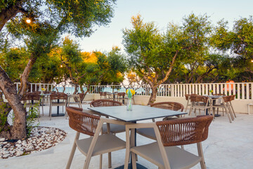 Tables in restaurant on the terrace . Zakynthos, Greece. Superb summer mood, outdoor restaurant. Romantic vibes, summer colors under blue sky