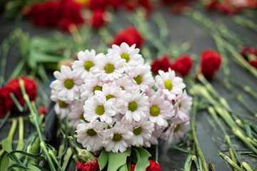 Obraz na płótnie Canvas Flowers on memorial. Bouquet of flowers on gravestone.
