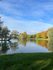 autumn trees reflection on the surface of the pond in the park, golden fall