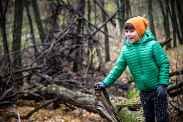 A child walking across a fallen tree going across a river in the