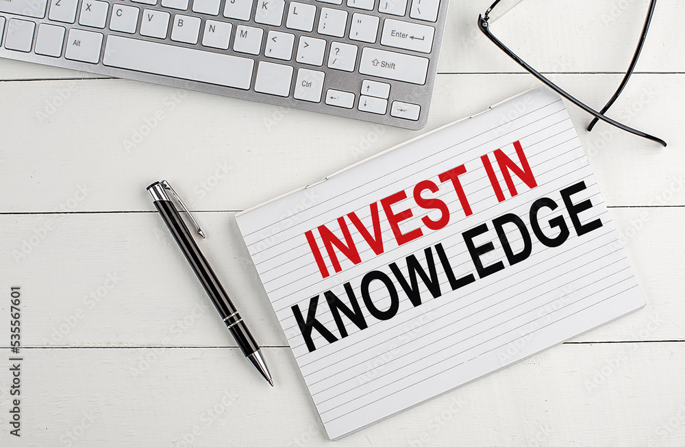 Aufkleber text invest in knowledge on keyboard on white background