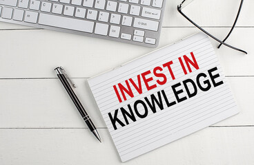 text INVEST IN KNOWLEDGE on keyboard on white background