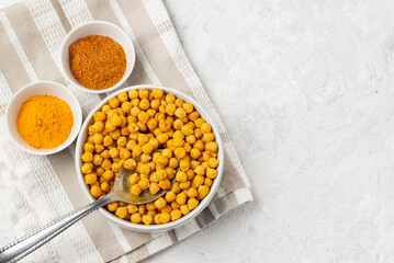 Roasting chickpeas with spices curry powder, garam masala and turmeric on napkin. Flat lay, top view with copy space