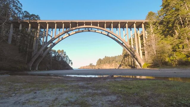 White man walking to beach and back at Russian Gulch State Park Bridge. Clear, blue sky timelapse 