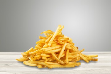 Tasty fast food French fries on desk