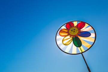 Children's pinwheel in windy weather against the blue sky on a Sunny day