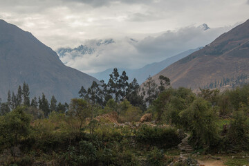 View of the Sacred Valley, trail between mountains, green and clouds, in Peru.
