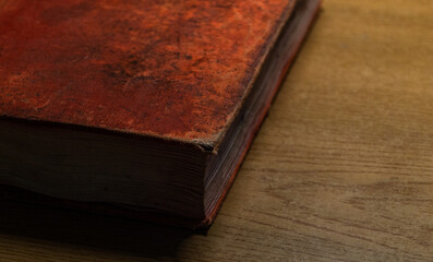 close up of old book with orange binding on the wooden table