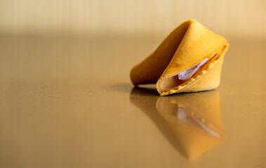 Single Fortune Cookie Reflects In Glossy Table Top