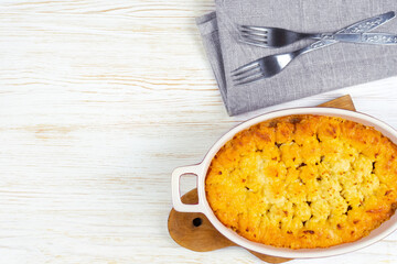 Shepherd's pie or Cottage pie. Minced meat, mashed potatoes and vegetables casserole on white wooden background. Traditonal British, United Kingdom, Ireland cuisine. Top view, flat lay with copy space