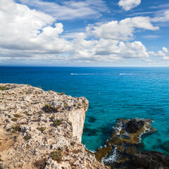 Coastal view with rocks and sea water under cloudy sky