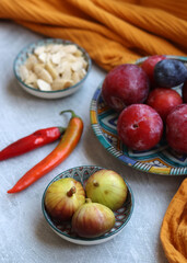 Still life with red plums on a blue ceramic plate. Eating fresh concept. 